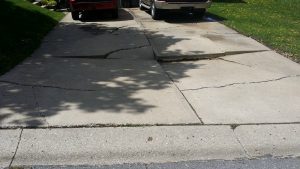 Driveway with slabs that are sinking and cracked. 